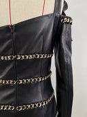 Chain-trimmed sleeve cuff detail