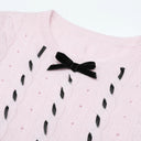 Blush pink sweater neckline with black velvet bow
